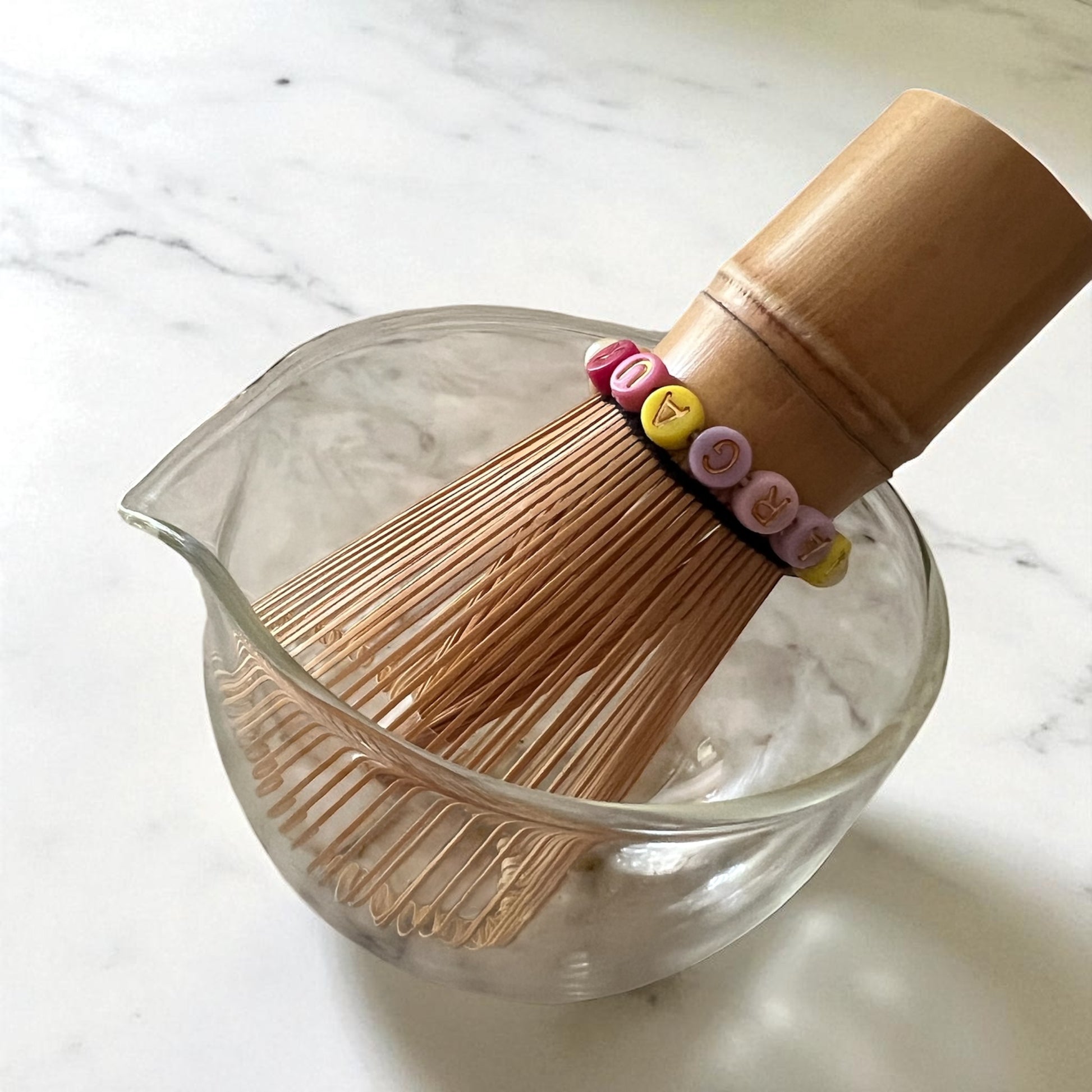 Fouet chasen personnalisé disposé à l'intérieur d'un bol en verre.