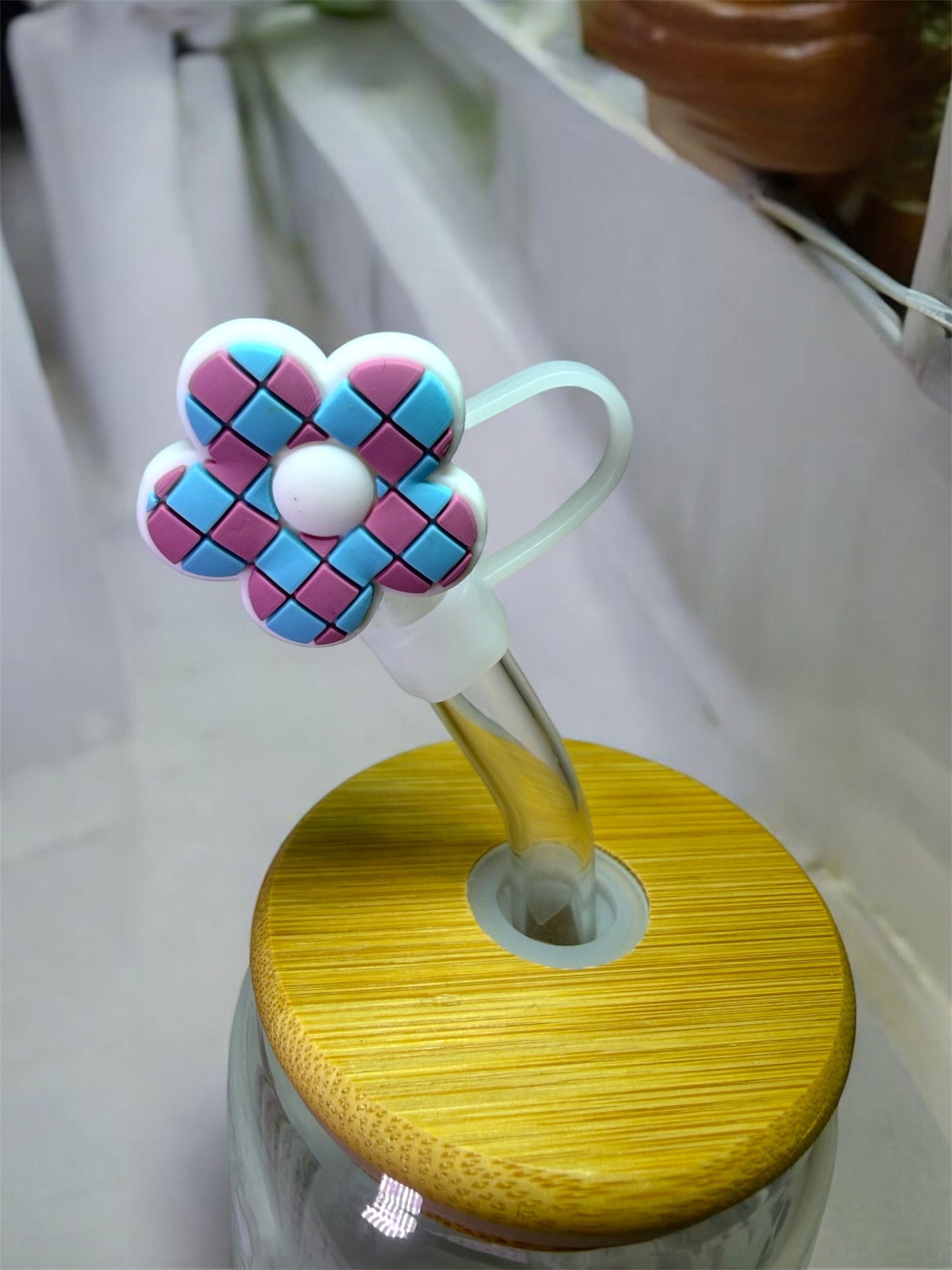 Vue rapprochée d'un embout de paille en silicone en forme de fleur rose et bleu
